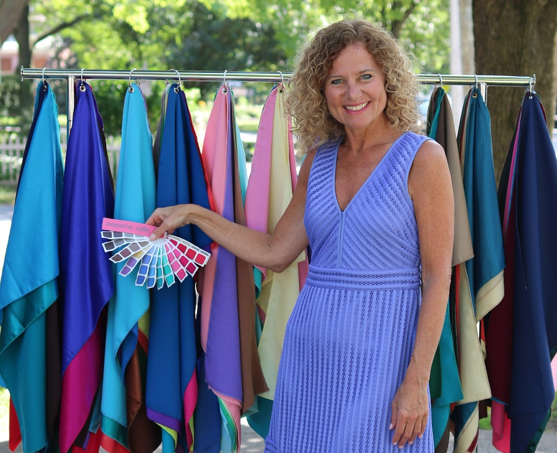 Personal Color Analyst Kerry Jones with Indigo Tones swatch book and rack of colorful drapes